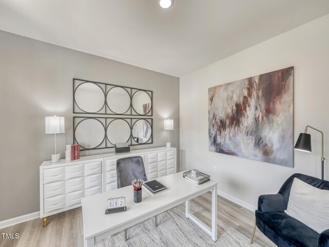 home office with baseboards and light wood finished floors