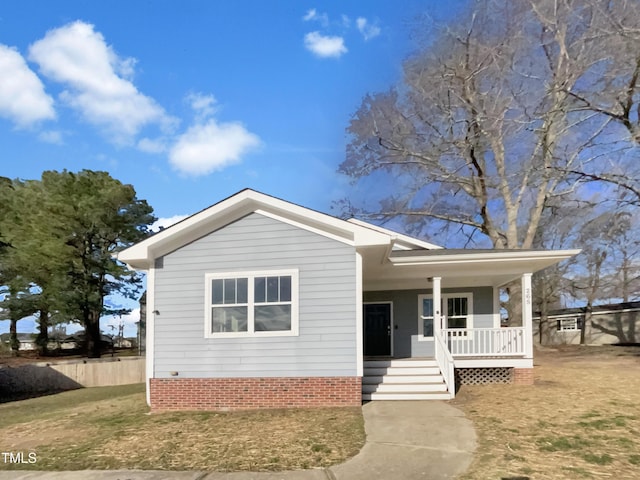 view of front facade with a porch, a front yard, and fence