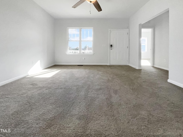 unfurnished room featuring carpet, a ceiling fan, and baseboards