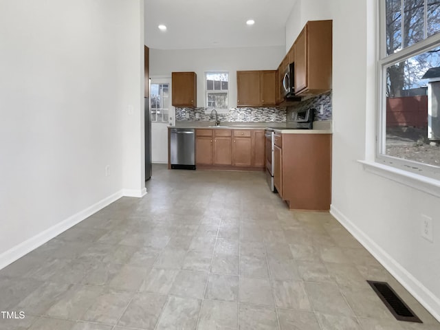 kitchen featuring a sink, visible vents, light countertops, appliances with stainless steel finishes, and backsplash