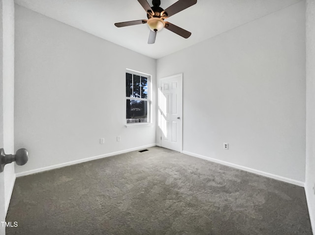 carpeted spare room featuring baseboards, visible vents, and a ceiling fan