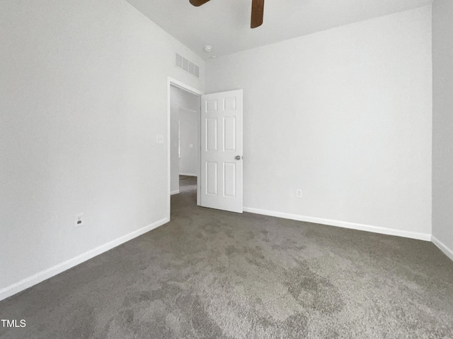 unfurnished bedroom with dark colored carpet, visible vents, ceiling fan, and baseboards