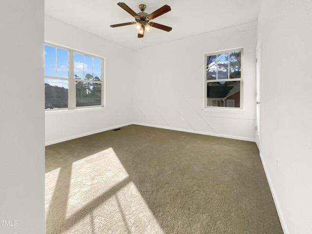 spare room with carpet floors, baseboards, and a ceiling fan