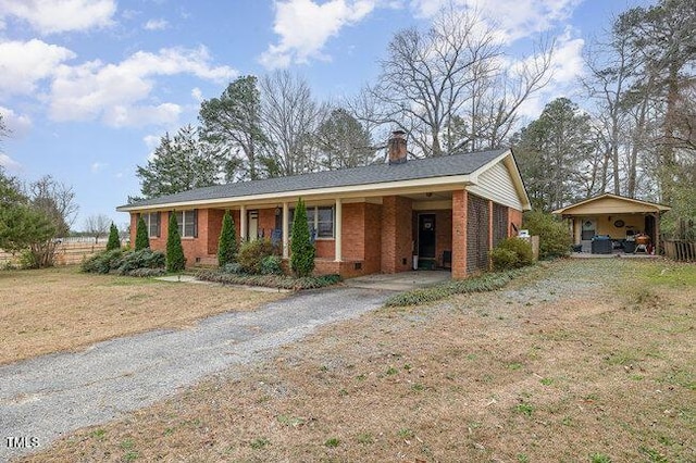 single story home featuring driveway, a chimney, crawl space, a front lawn, and brick siding