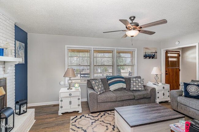 living area featuring ceiling fan, a textured ceiling, baseboards, and wood finished floors