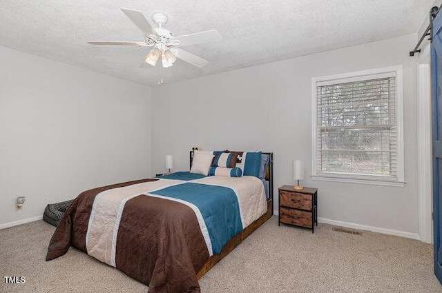 carpeted bedroom featuring ceiling fan, a textured ceiling, and baseboards