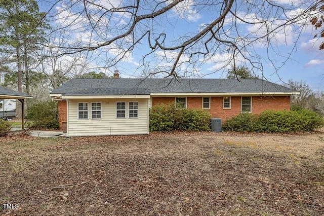 rear view of property featuring brick siding and central air condition unit