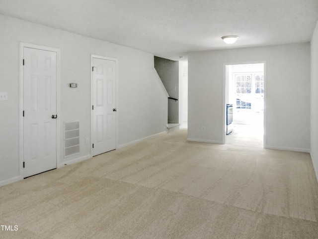 carpeted empty room featuring visible vents and baseboards