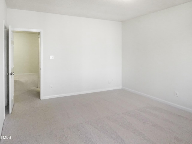 empty room with baseboards and light colored carpet