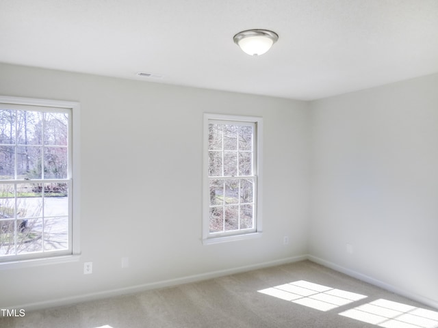 spare room with visible vents, baseboards, and carpet floors