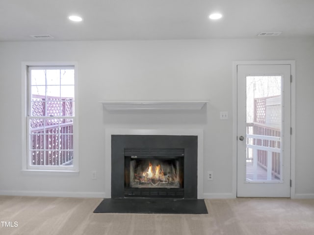 details featuring visible vents, recessed lighting, carpet, and a fireplace with flush hearth