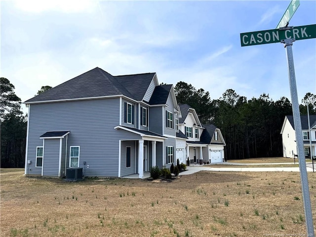 view of front of house with central air condition unit and a garage