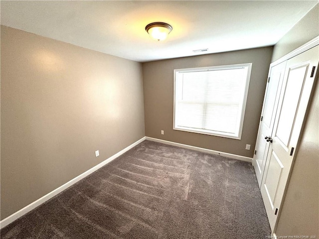 unfurnished bedroom with a closet, carpet flooring, and baseboards