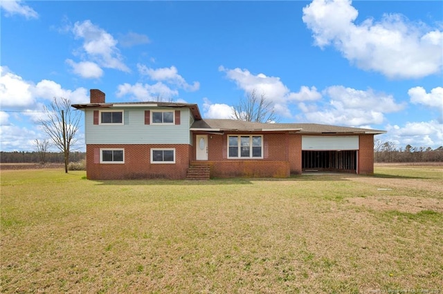 split level home with a front yard, brick siding, a chimney, and an attached garage