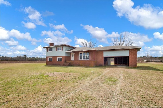 tri-level home featuring driveway, a front lawn, an attached garage, and brick siding