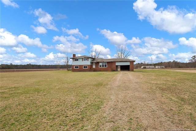 tri-level home featuring dirt driveway and a front yard