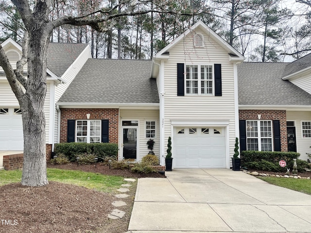 traditional-style house with brick siding, concrete driveway, and roof with shingles