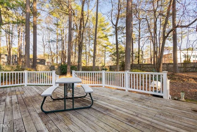 wooden terrace with a fenced backyard