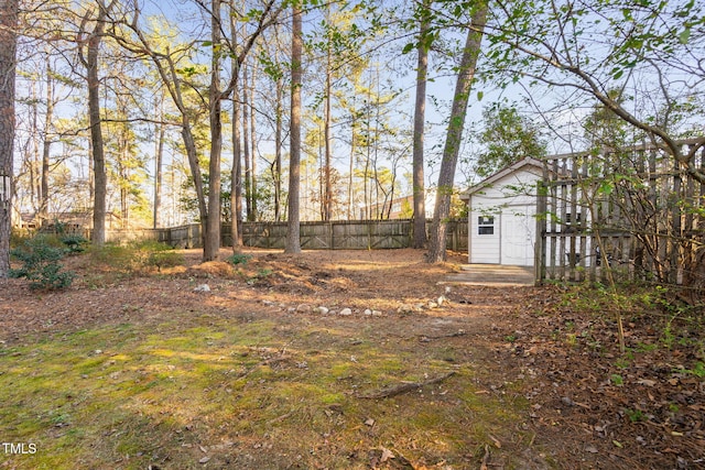view of yard with a storage shed, a fenced backyard, and an outdoor structure