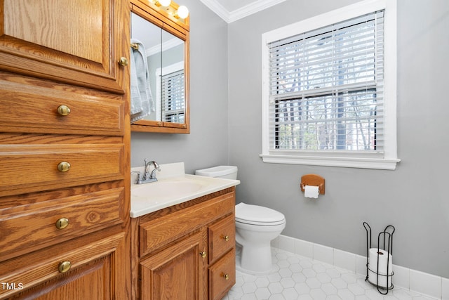 half bathroom featuring toilet, vanity, baseboards, ornamental molding, and tile patterned floors