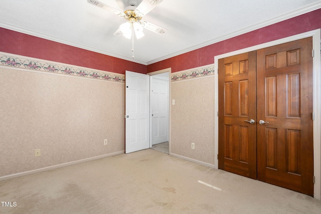 unfurnished bedroom with ceiling fan, carpet floors, baseboards, a closet, and wallpapered walls