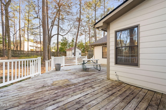 deck featuring a storage unit, an outdoor structure, and fence