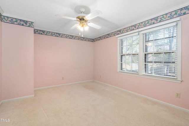 empty room featuring crown molding, light carpet, ceiling fan, and baseboards