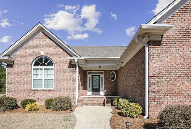 doorway to property featuring brick siding