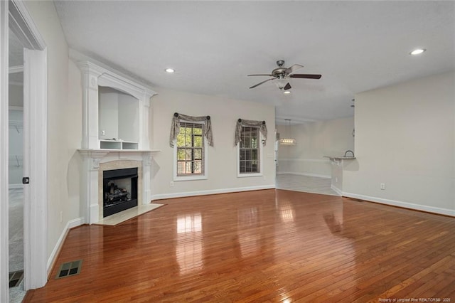 4305 Sanderosa Rd, Fayetteville, NC 28312 - unfurnished living room featuring wood-type flooring, visible vents, ceiling fan, and a premium fireplace