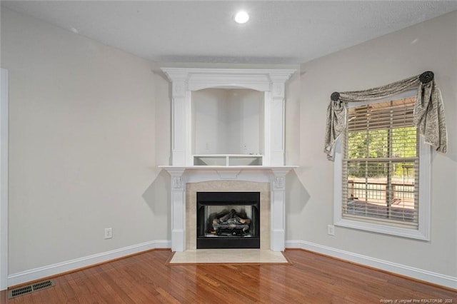 4305 Sanderosa Rd, Fayetteville, NC 28312 - unfurnished living room featuring a fireplace with flush hearth, visible vents, baseboards, and wood finished floors