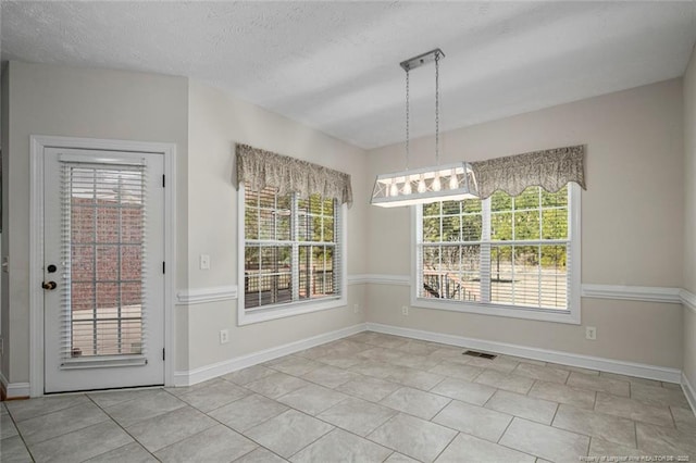 4305 Sanderosa Rd, Fayetteville, NC 28312 - unfurnished dining area with a textured ceiling, tile patterned flooring, visible vents, and baseboards