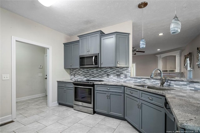 4305 Sanderosa Rd, Fayetteville, NC 28312 - kitchen featuring light stone counters, backsplash, gray cabinetry, appliances with stainless steel finishes, and a sink