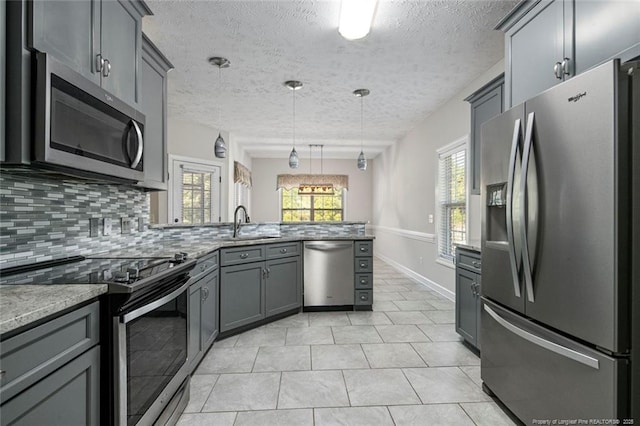 4305 Sanderosa Rd, Fayetteville, NC 28312 - kitchen featuring stainless steel appliances, a peninsula, a sink, backsplash, and gray cabinets