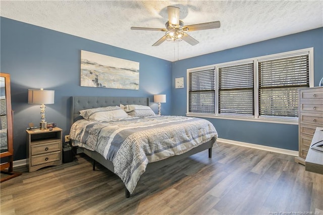 bedroom featuring a textured ceiling, baseboards, and wood finished floors