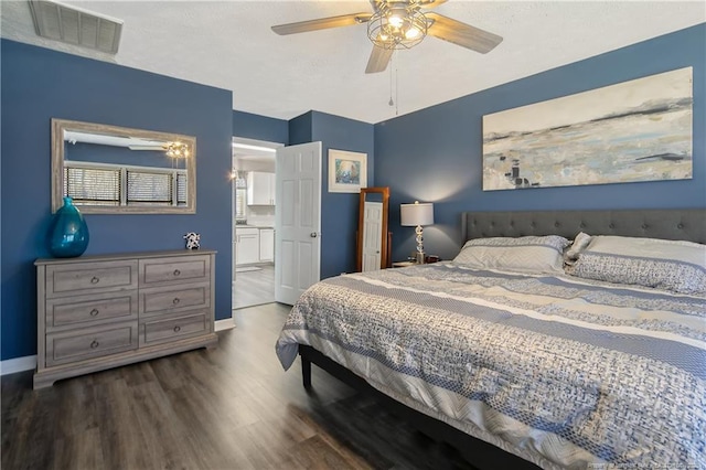 bedroom featuring visible vents, ceiling fan, connected bathroom, wood finished floors, and baseboards