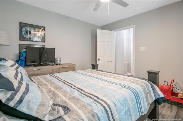 bedroom with visible vents, wood finished floors, and a ceiling fan