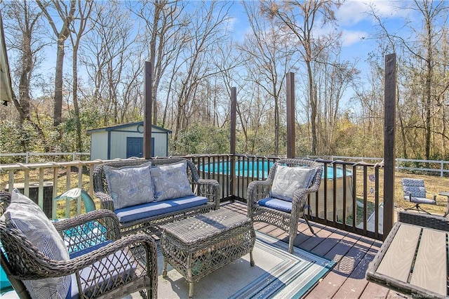 wooden deck with an outdoor structure, an outdoor living space, a swimming pool, and a shed