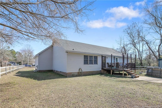 back of house with a shingled roof, a wooden deck, a fenced backyard, crawl space, and a yard