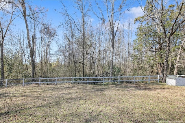 view of yard with a storage shed, fence, and an outbuilding