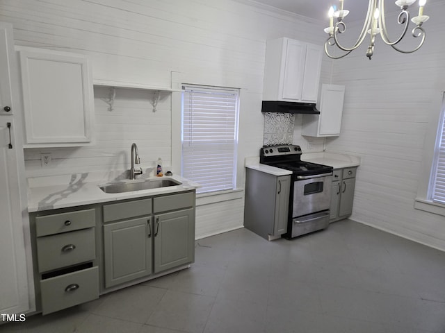 kitchen with under cabinet range hood, a sink, white cabinets, stainless steel range with electric cooktop, and light countertops