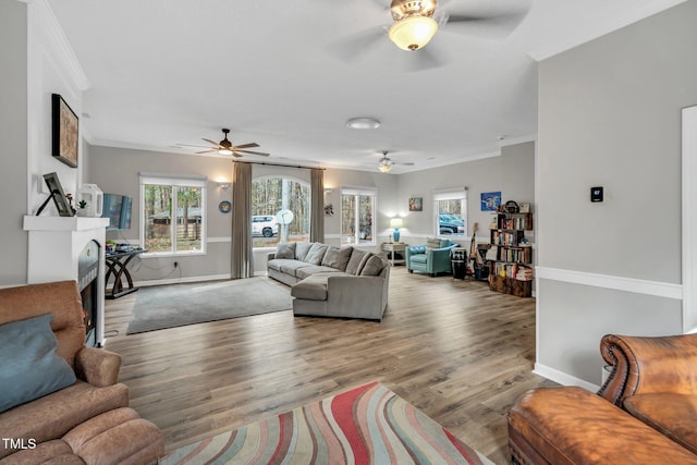 living area with ornamental molding, wood finished floors, and baseboards