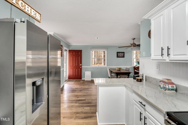 kitchen featuring white cabinets, wood finished floors, range with electric cooktop, a peninsula, and stainless steel fridge with ice dispenser