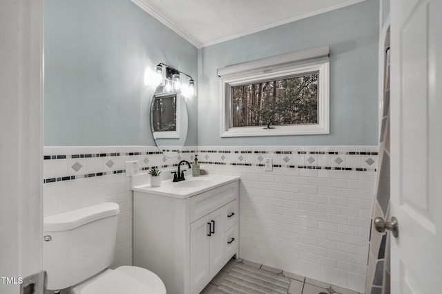 half bath with crown molding, tile walls, toilet, and vanity