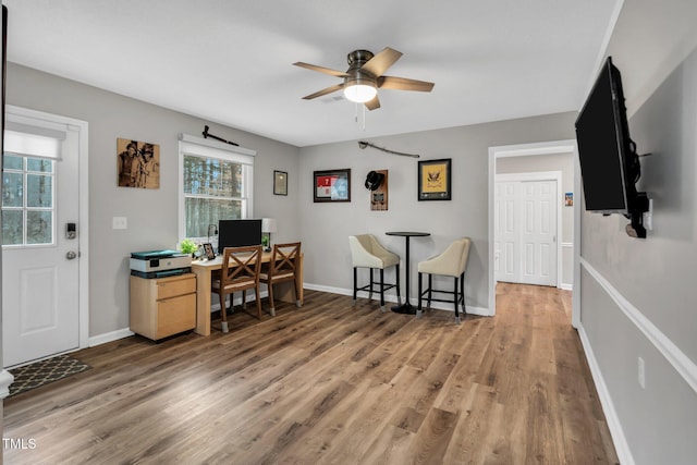 home office featuring a ceiling fan, light wood-type flooring, and baseboards