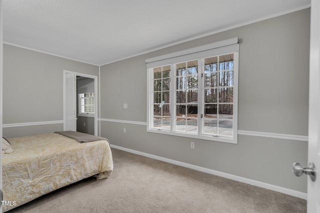 bedroom featuring carpet floors, baseboards, and crown molding