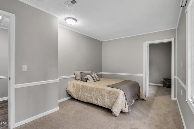 carpeted bedroom featuring visible vents, crown molding, a textured ceiling, and baseboards