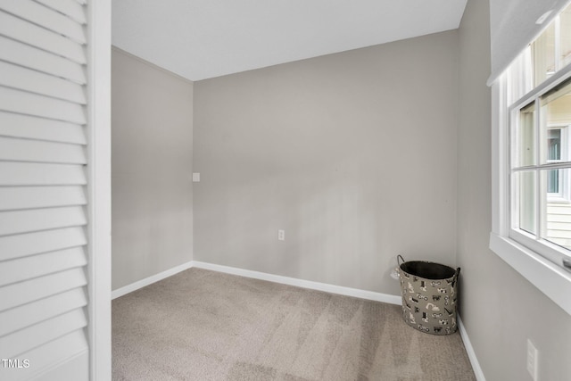 carpeted empty room with baseboards