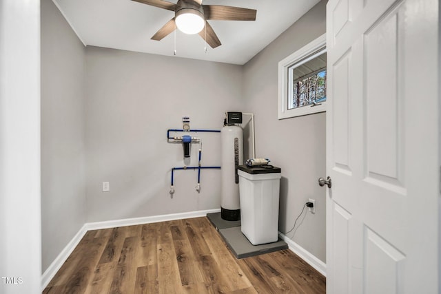 clothes washing area featuring a ceiling fan, laundry area, baseboards, and wood finished floors