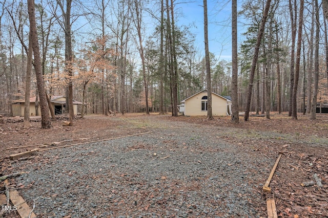 view of yard with a forest view and an outdoor structure