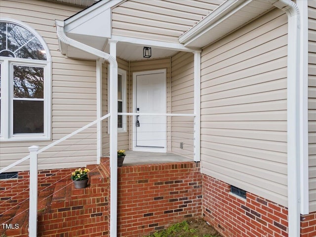 entrance to property with crawl space and brick siding